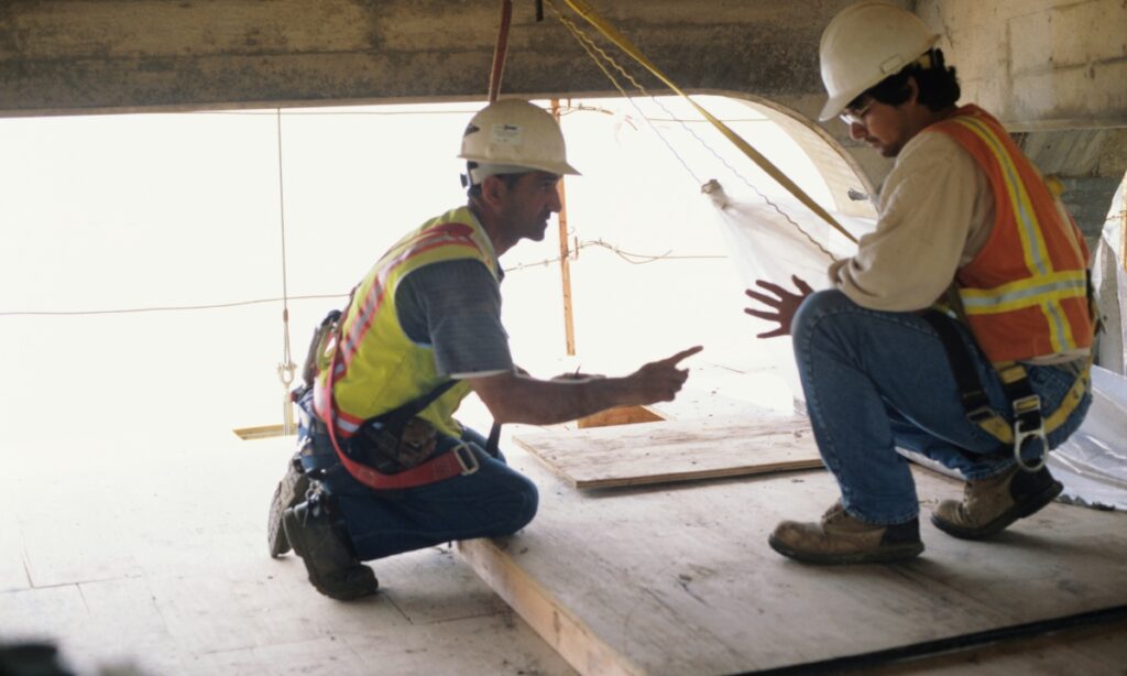 Two men under a bridge in protective harnesses 